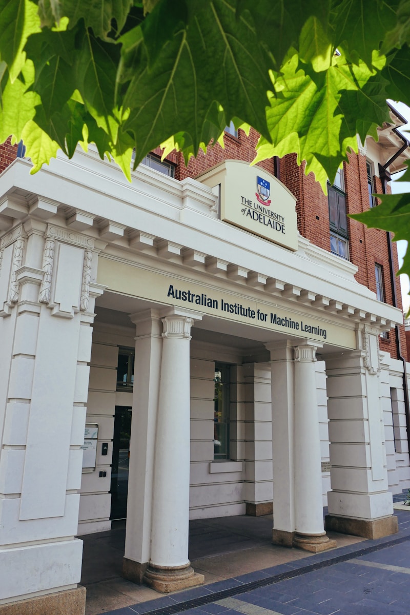 A white building with columns and a sign on the front of it